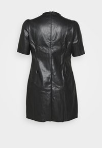 Robe en cuir noir avec des manches courtes, silhouette ajustée, fermeture éclair dans le dos et texture lisse. Aucun motif ni accent visible.