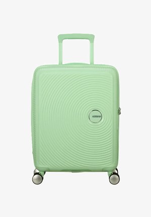 Maleta rígida en verde menta con patrones de olas circulares, mango retráctil y ruedas dobles para una fácil movilidad.