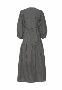 Fekete-fehér kockás ruha pöttyös ujjakkal, deréknál szűkített és rakott szoknyával. Könnyű anyagból készült, egyszerű, kerek nyakkivágással.