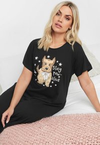 Maglietta nera a maniche corte con una stampa di un'illustrazione di cane accompagnata dal testo "stay paw-sitive" e stelle. Tessuto morbido e casual.