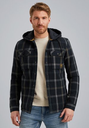 Plaid flannel jacket in dark blue and gray, featuring a black hood, two chest pockets, and button closures. Accented with yellow lining.