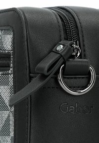 Borsa a mano nera in material sintetico con finitura testurizzata, dotata di chiusura a zip e un dettaglio in metallo circolare. Il logo è impresso sul lato.