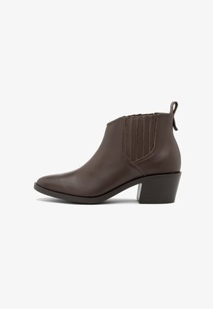 Brązowy skórzany botek za kostkę z ostrym noskiem, elastycznymi bocznymi panelami i niskim, blokowym obcasem. Posiada gładką teksturę i minimalistyczny design.