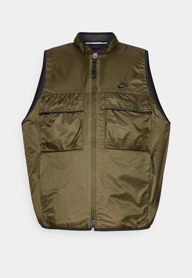 Gilet sans manches vert olive avec deux poches zippées à l'avant, fermeture éclair noire et petit logo Nike noir sur la poitrine.