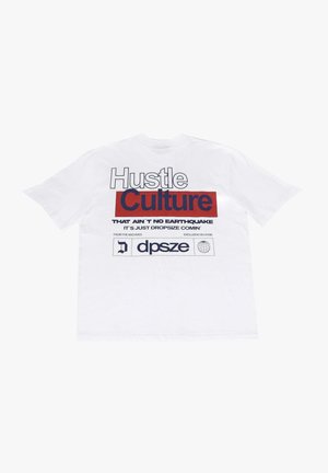 T-shirt bianco in cotone con testo audace in nero e rosso: "Hustle Culture" e frasi sottostanti. Maniche corte e scollatura a girocollo standard.