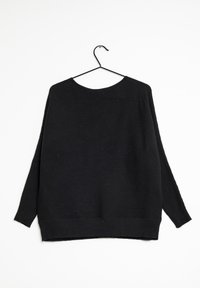 Pull noir côtelé à manches longues avec un col rond et une coupe ample. Présente un ourlet droit avec des fentes sur les côtés, fabriqué en tissu tricoté texturé.