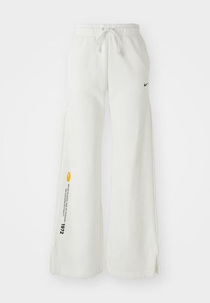 Pantaloni felpati bianchi a gamba larga con vita elasticizzata, coulisse, spacchi laterali, logo Nike nero e testo grafico giallo a contrasto.