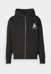 Černá mikina na zip vyrobená z měkké tkaniny, s klokaní kapsou, žebrovanými manžetami a grafickým potiskem na levé hrudi.