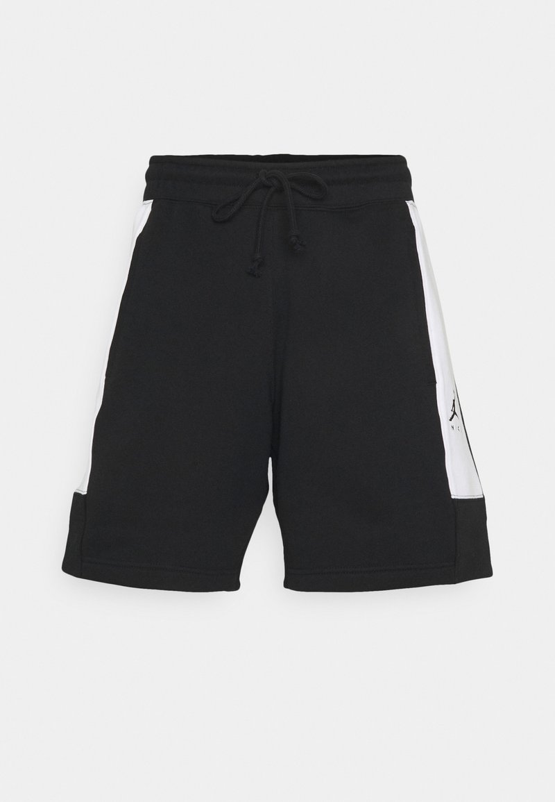 Shorts de sport noirs avec des panneaux latéraux blancs et une taille à cordon, exposés sur un fond gris clair uni.