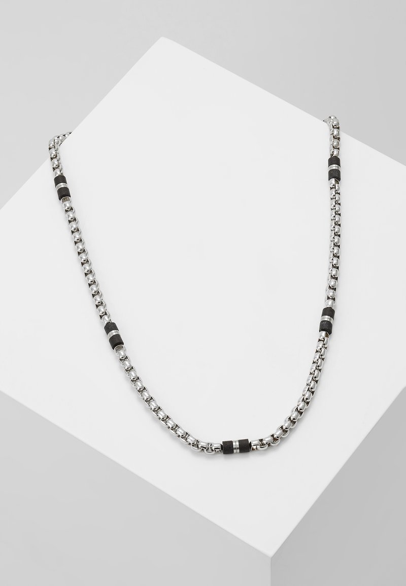 Collier en chaîne argentée avec des segments noirs dispersés. Les maillons sont texturés, offrant un mélange de finitions brillantes et mates.