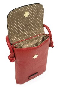 Bolso bandolera de cuero rojo con herrajes dorados, forro de lunares y correa con estilo de nudo. El interior cuenta con un único compartimento.