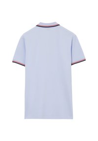 Polo shirt a maniche corte blu chiaro con bordi a righe navy, rossi e bianchi sul colletto e sui bordi delle maniche, visto da dietro.