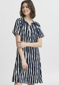 Rochie cu mânecă scurtă, cu dungi verticale bleumarin și crem, având un decolteu în V și dintr-un material moale, texturat care cade până la mijlocul coapsei.