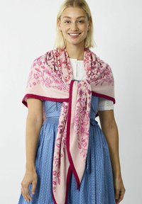 Châle rose clair avec des motifs floraux et des bordures rose foncé, drapé sur une robe bleue. Tissu doux et texturé avec une finition confortable.