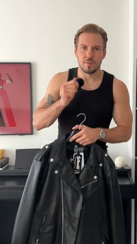 Černá kožená motocyklová bunda s ramenními epauletami, stříbrným kováním, zipovými kapsami a klasickým asymetrickým designem.