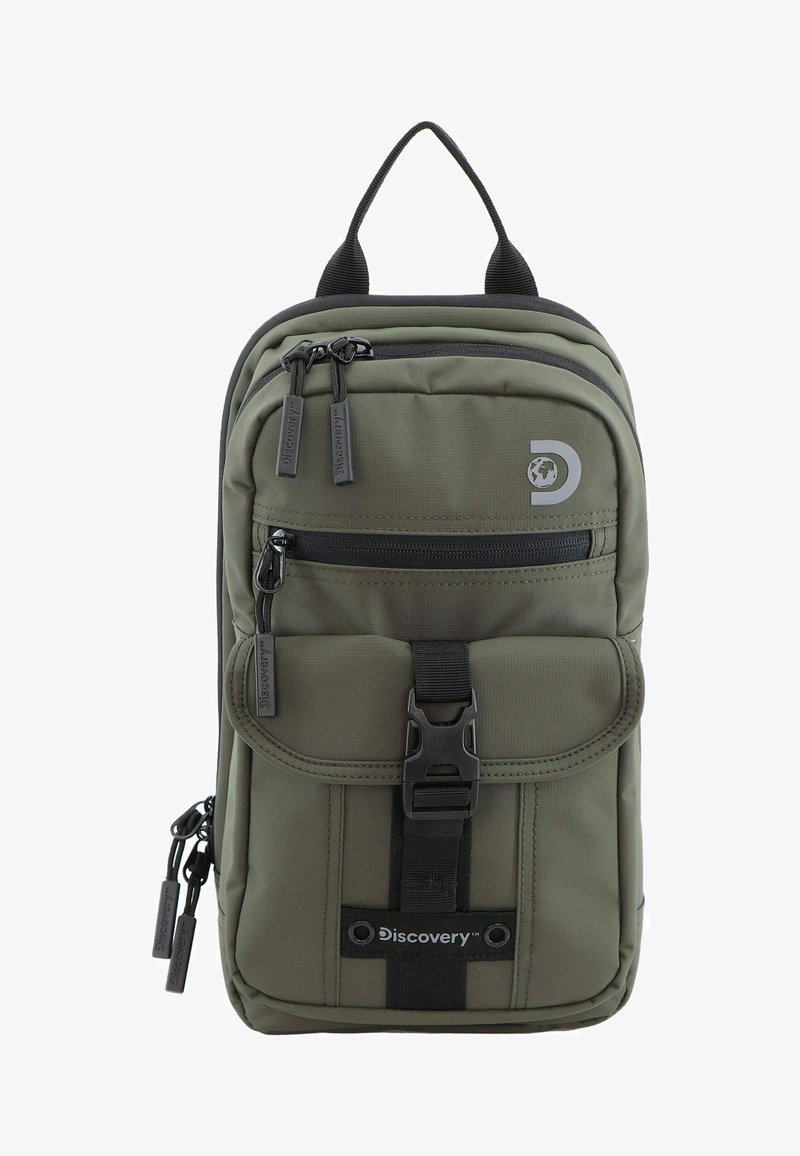 Mochila de color verde oliva con un compartimento principal con cremallera, un bolsillo con solapa en la parte delantera y detalles en negro. Cuenta con cremalleras dobles y un asa de transporte en la parte superior.