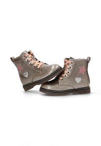 Botas de tobillo doradas brillantes con diseños de estrellas y corazones rosas, cordones en color marrón, suelas de goma y costuras negras contrastantes.