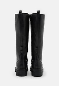 Korkeat mustat nahkasaappaat, joissa on sileä pinta, varustettuna takana olevan vetoketjun, vetotaskujen ja paksun kumipohjan kanssa, joka tarjoaa pitoa.