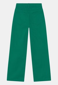 Gröna vida byxor med bältesöglor och två bakfickor, visade platt bakifrån mot en vit bakgrund.