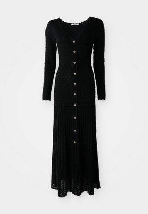 Robes maxi noires en tricot avec manches longues, décolleté en V, devant à boutons, texture côtelée, motif en diamant et deux poches avant. Détails en boutons dorés.