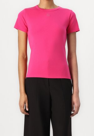 T-shirt ajusté à manches courtes en coton rose vif, avec un col rond et un logo "HUGO" discret embossé sur la poitrine.