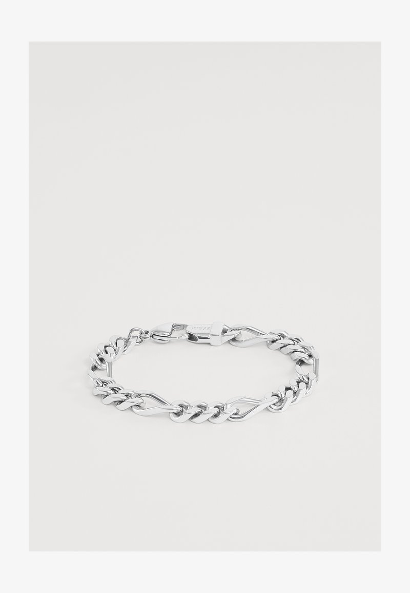 Bracelet chaîne en argent avec des maillons torsadés et plats alternés et un fermoir griffe de homard sur un fond clair uni.
