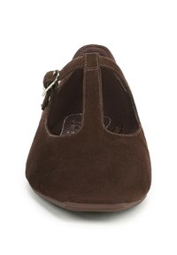 Bruine suede platte schoen met een ronde neus, uitgesneden ontwerp bij de hiel, en een band met een metalen gesp voor een veilige sluiting.