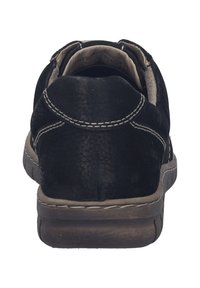 Scarpa in pelle nera, forma arrotondata con cuciture a contrasto, fodera morbida e superficie testurizzata. Suola in gomma grigia con un tacco modesto.