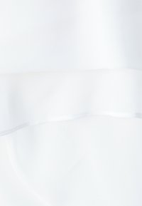 Tissu blanc transparent avec une texture lisse, superposé à un morceau légèrement opaque. Les bords sont soigneusement finis sans coutures visibles.