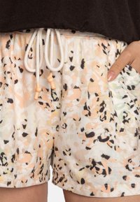 Lichte shorts in een pastelkleurig abstract bloemmotief met een trekkoord in de tailleband, voorzien van beige, roze en zwarte accenten.