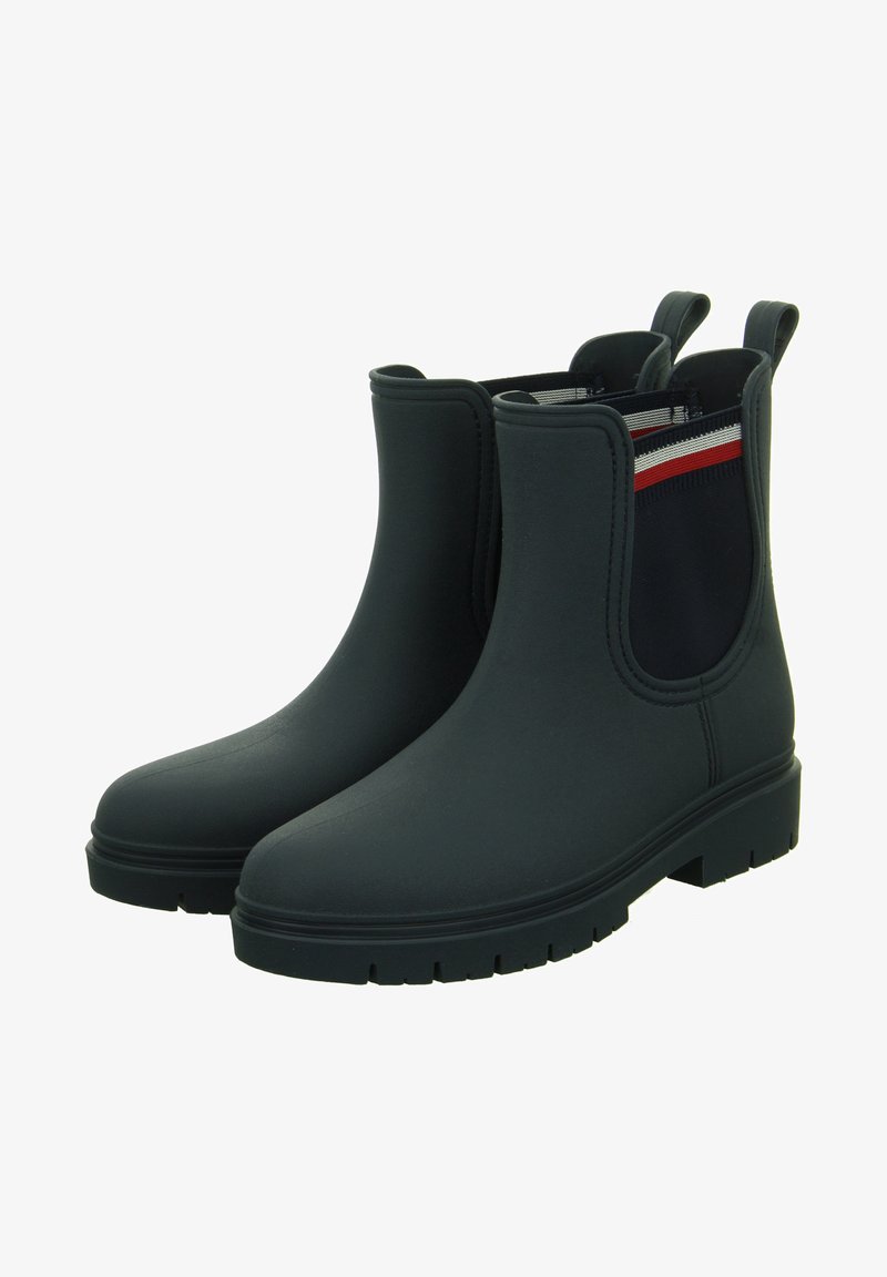 Stivaletti neri impermeabili alla caviglia con una finitura liscia, pannelli elastici laterali in blu navy con strisce rosse e bianche, e una suola in gomma texture.