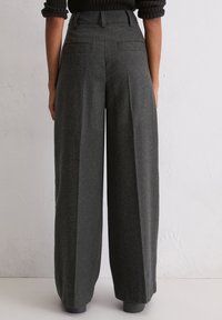 Pantaloni a gamba larga in tessuto grigio scuro, con vita alta, due tasche posteriori e finitura testurizzata. Adatti per abbigliamento casual o formale.