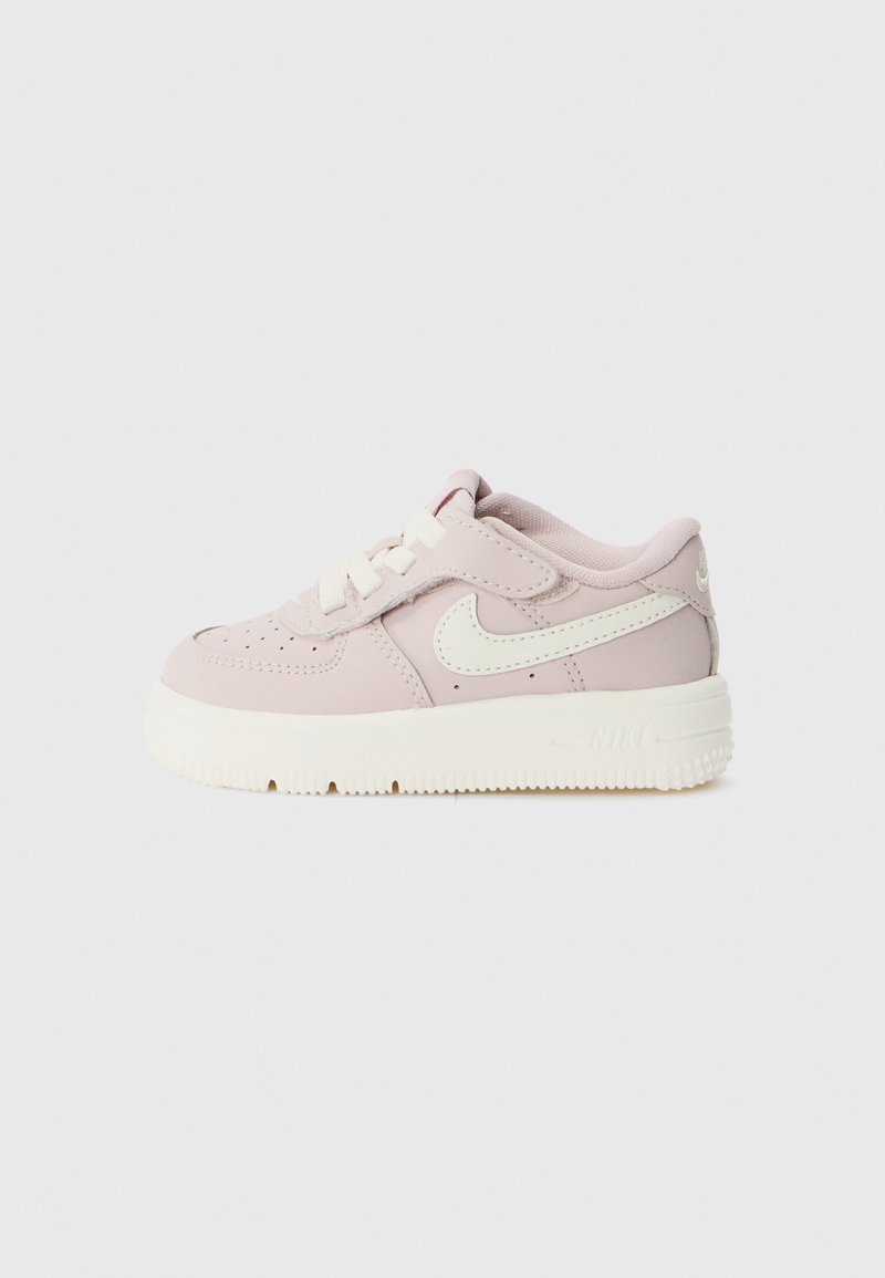 Sneakers in pelle rosa con swoosh bianco, lacci piatti, colletto imbottito, suola testurizzata e piccola etichetta sul tallone e sul lato.