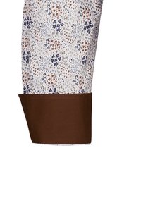 Musterärmel mit floralem Design in Blau, Braun und Weiß, mit einem kontrastierenden braunen Bund und einer glatten Stoffstruktur.