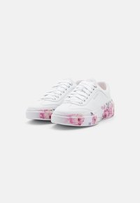 Białe trampki z kwiatowym nadrukiem na gumowej podeszwie, z gładką skórzaną cholewką, okrągłym noskiem i płaskimi sznurowadłami. Dodatkowe akcenty to srebrne przelotki.