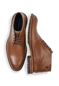 Bruine leren schoenen met een gladde afwerking, voorzien van veters, een ronde neus en een robuuste zool. Inclusief contrasterende zoolaccenten.