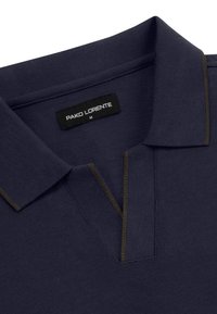 Granatowa koszulka polo z teksturowanej tkaniny, z klasycznym kołnierzykiem i kontrastującymi przeszyciami wzdłuż pliski oraz krawędzi kołnierza.