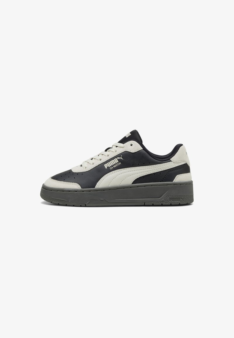 Adidași din piele neagră și gri, cu accente albe, vârf perforat, talpă din cauciuc texturat și logo PUMA pe lateral și pe limbă.