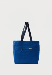 Μπλε καμβά τσάντα ώμου με εμπρόσθια τσέπη με φερμουάρ, διπλούς ιμάντες ώμου και ορθογώνιο σχήμα. Διαθέτει διακριτική ετικέτα με το λογότυπο της μάρκας.