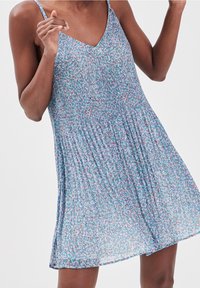 Robe sans manches à motif floral avec un décolleté en V et une texture plissée. Confectionnée en tissu léger aux nuances de bleu, rose et vert.