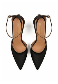 Schwarze Satin-High-Heels mit spitzem Zehenbereich, Knöchelriemen und beiger Innensohle, die eine glatte Textur und ein minimalistisches Design aufweisen.