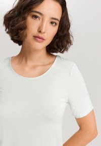 Top de manga corta azul claro con escote redondeado, fabricado en un suave tejido texturizado. Presenta un corte relajado y un diseño minimalista.