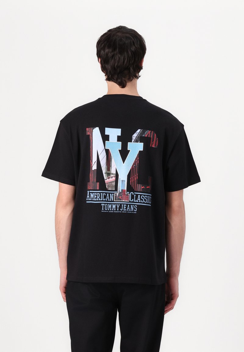 Zwarte katoenen t-shirt met een grote "NY" grafiek in blauw en rood, met daaronder de teksten "American Classics" en "Tommy Jeans".