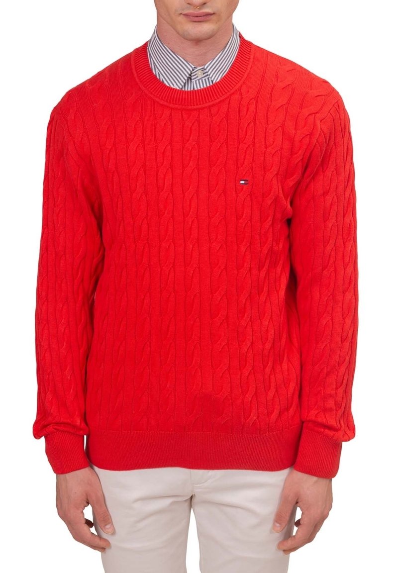 Pull en tricot rouge avec un motif torsadé, col rond, poignets et ourlet côtelés. Présente un petit logo sur la poitrine.