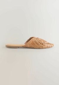 Mules en cuir naturel à enfiler avec design tissé, couleur marron clair, texture lisse et semelle plate. Pas de quincaillerie ni d'accents visibles.