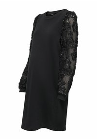 Robe noire avec un décolleté rond et des manches longues, présentant un tissu texturé et des appliqués floraux avec des sequins, tissu du corps lisse.