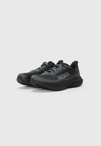 Zwarte hardloopschoenen met een bovenwerk van mesh, een cushioned zool en een prominent "HOKA" logo. Voorzien van veters en een ronde neus voor ondersteuning.