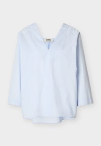 Ανοιχτό μπλε μπλούζα με μακριά μανίκια, βαθύ V-λαιμόκοψη και χαλαρή εφαρμογή, εμφανίζεται σε λευκό φόντο.