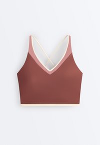 Crop top w kolorze brązowym i różowym z cienkimi kremowymi skrzyżowanymi ramiączkami oraz kremową lamówką na dole, ułożony płasko na białym tle.