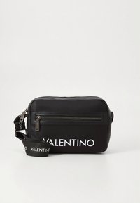 Sort tversoversekk i nylon med glidelåslomme, med "VALENTINO"-logo i hvitt. Justerbar stropp med logo-detalj. Rektangulær form.